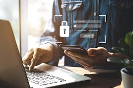 Mann vor Laptop mit Smartphone Mann vor Laptop mit Smartphone